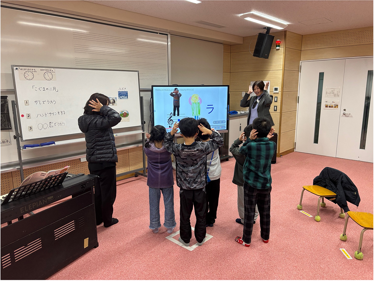 教室で児童が電子黒板を使って授業を受けている様子。